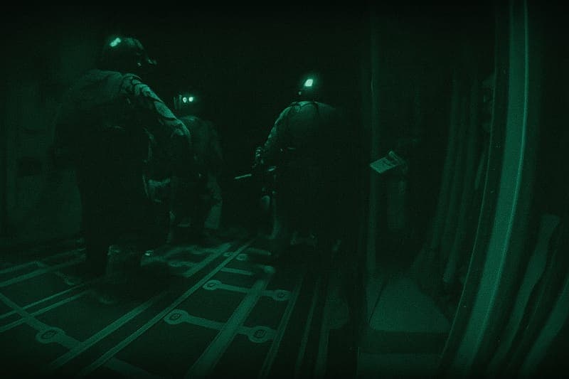 Special Forces soldiers jumping out from military aircraft during HALO jump operation, captured at the moment of exit showing the beginning of their high-altitude tactical insertion mission