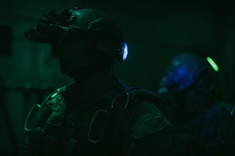 Two Special Forces soldiers standing inside military aircraft during mission briefing, wearing full tactical gear and preparing for high-altitude HALO jump operation